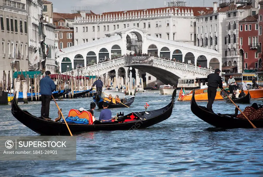 Gondolas on canal, bridge in the background, Venice, Italy