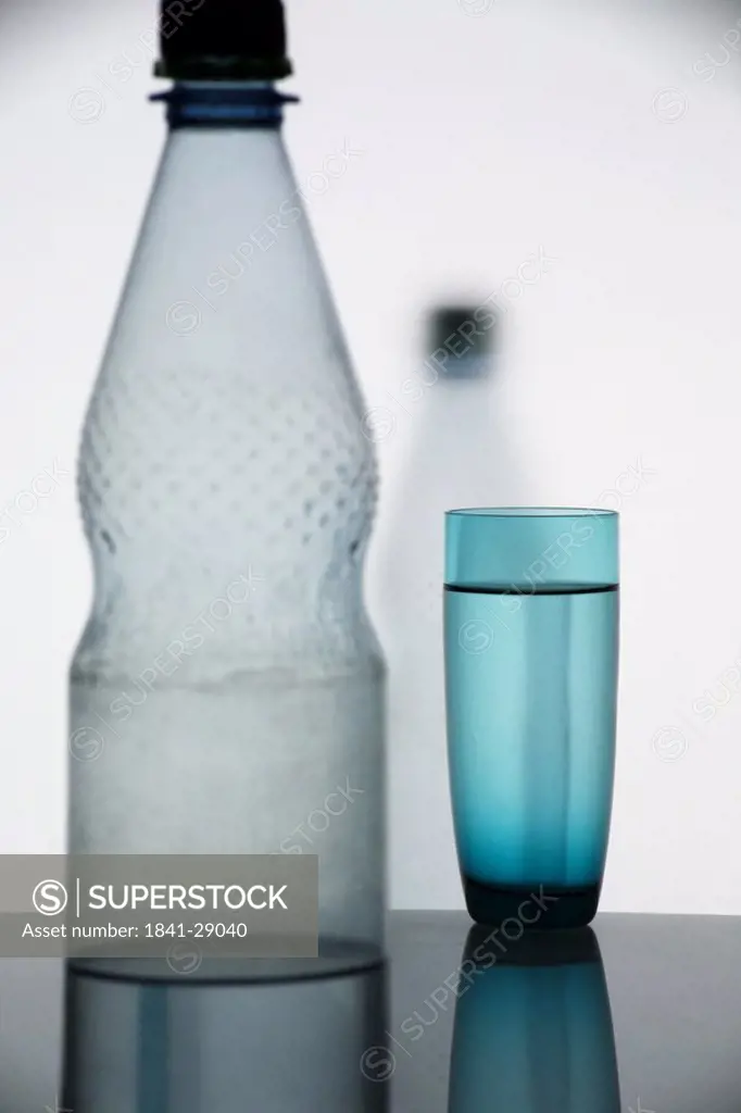 Close_up of water glass and water bottle on table