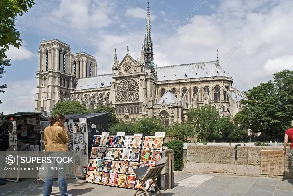Woman standing near roadside stall in front of cathedral