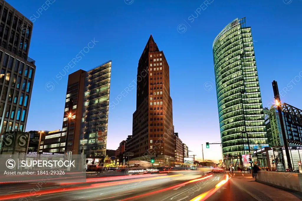 Skyscrapers lit up at dusk, BahnTower, Kollhoff Tower, Potsdamer Platz, Berlin, Germany