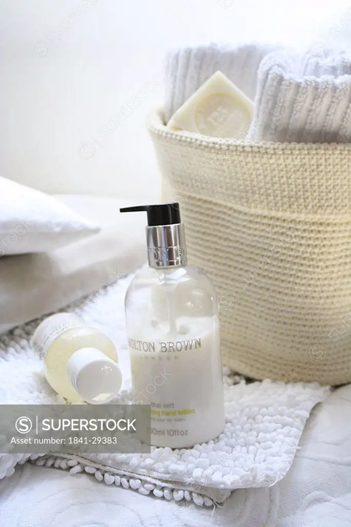 Close_up of bottles of moisturizers on towel