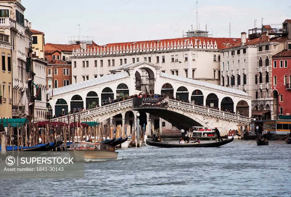 Gondola and motorboat on canal close to bridge, Venice, Italy