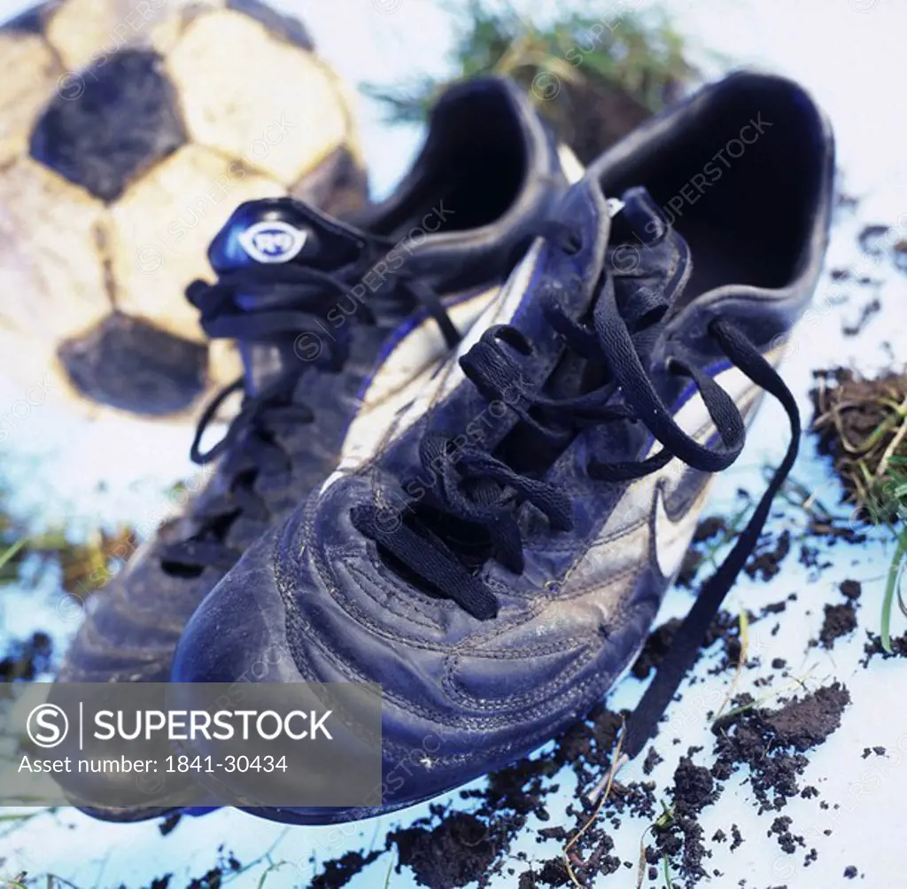 Close_up of pair of soccer shoes and ball