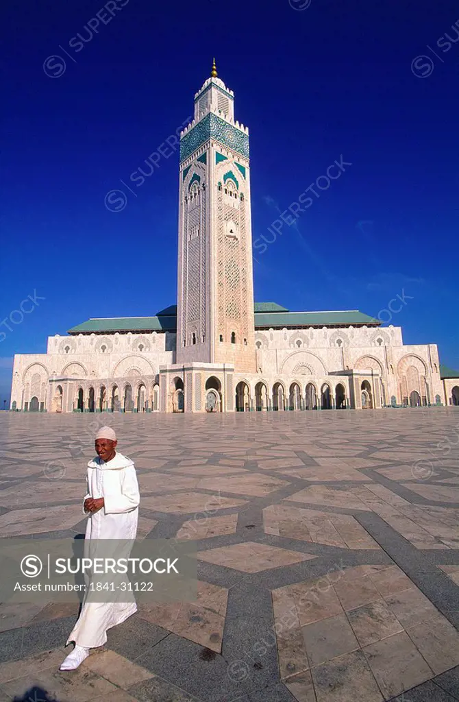 Man walking in front of mosque, Grande Mosque Hassan II, Casablanca, Morocco