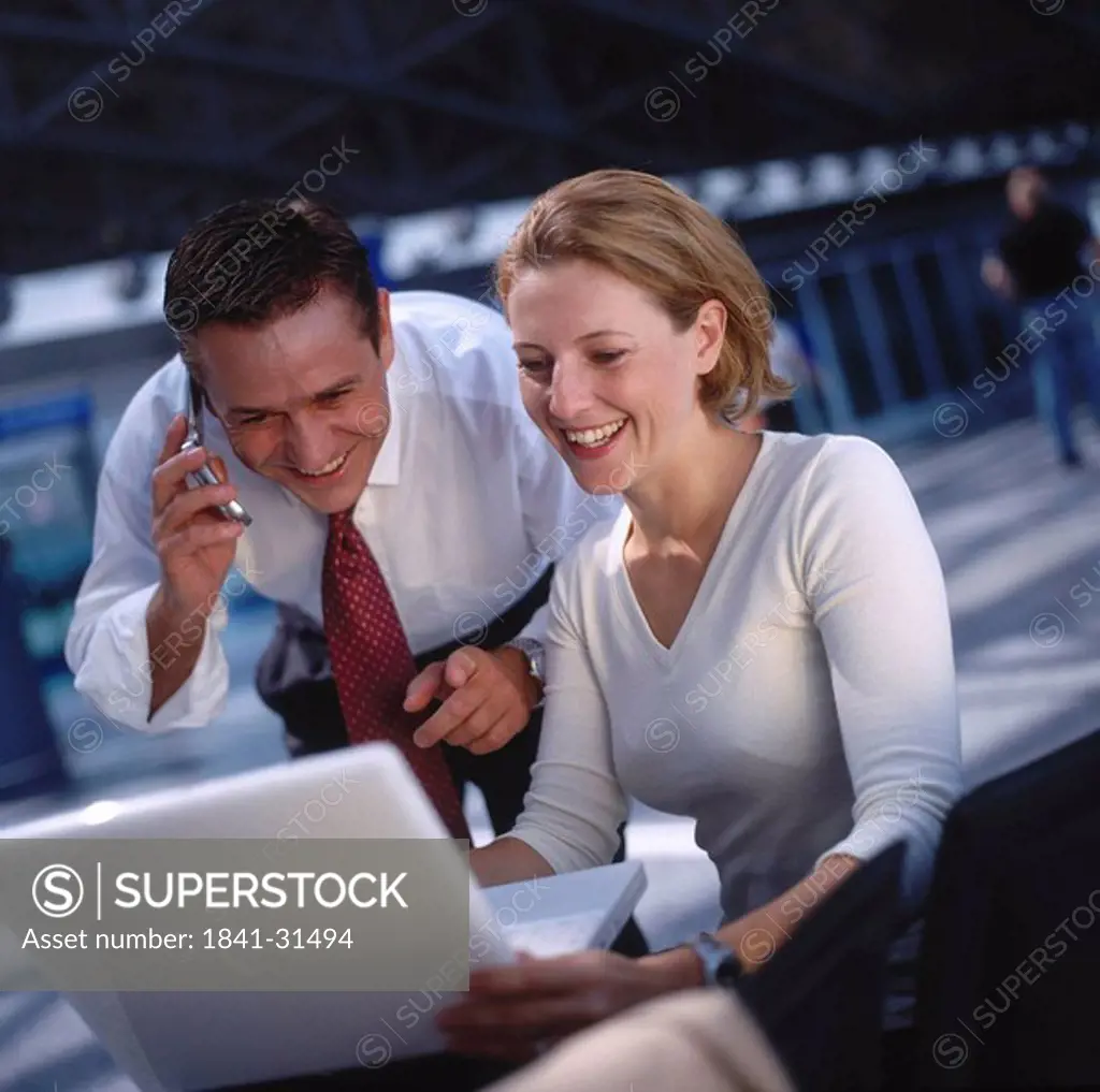 Two businesspeople with laptop and moblie phone