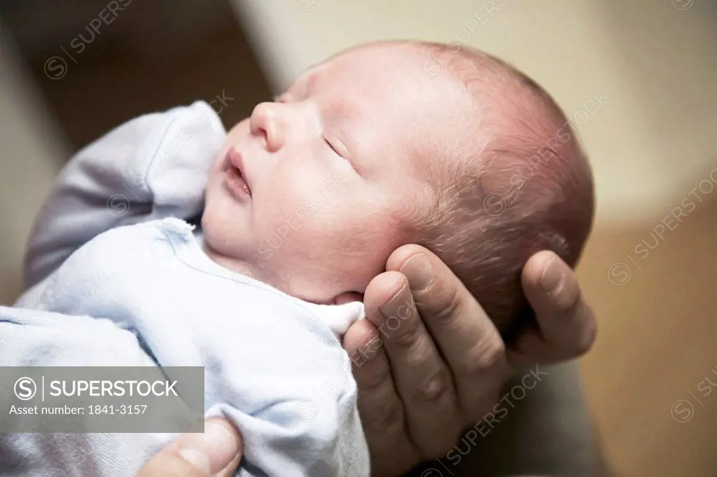 Man holding a sleeping baby in his hands, close_up