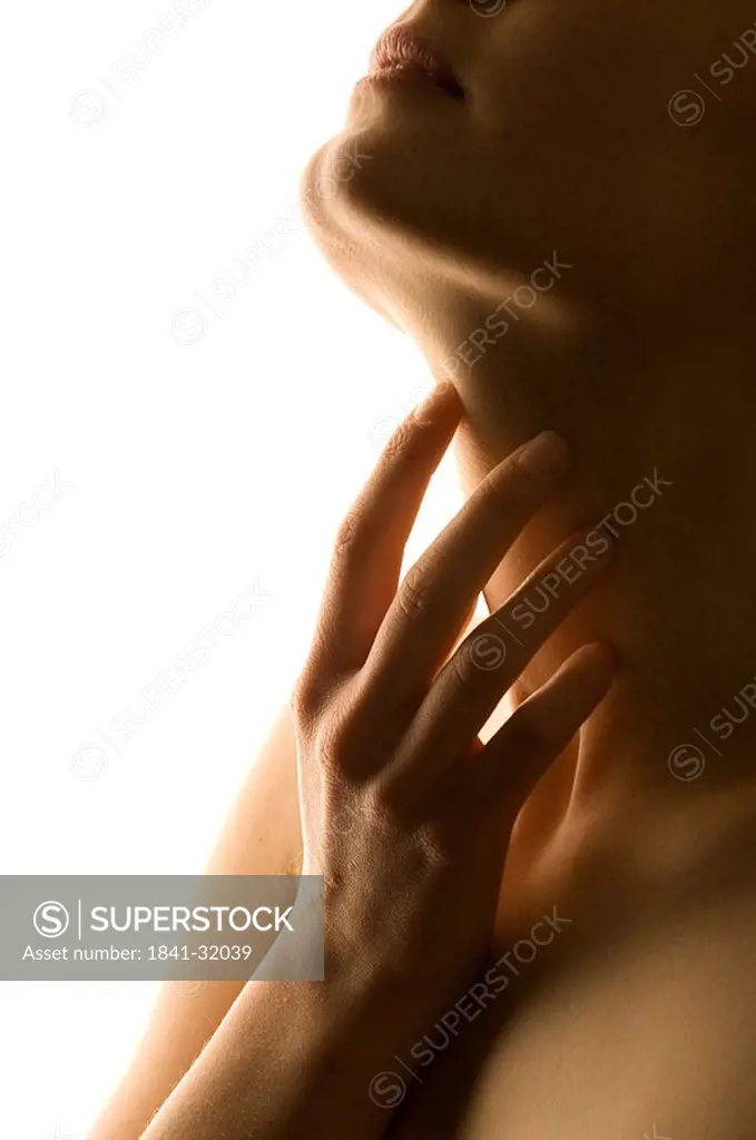 Close_up of young woman touching her throat