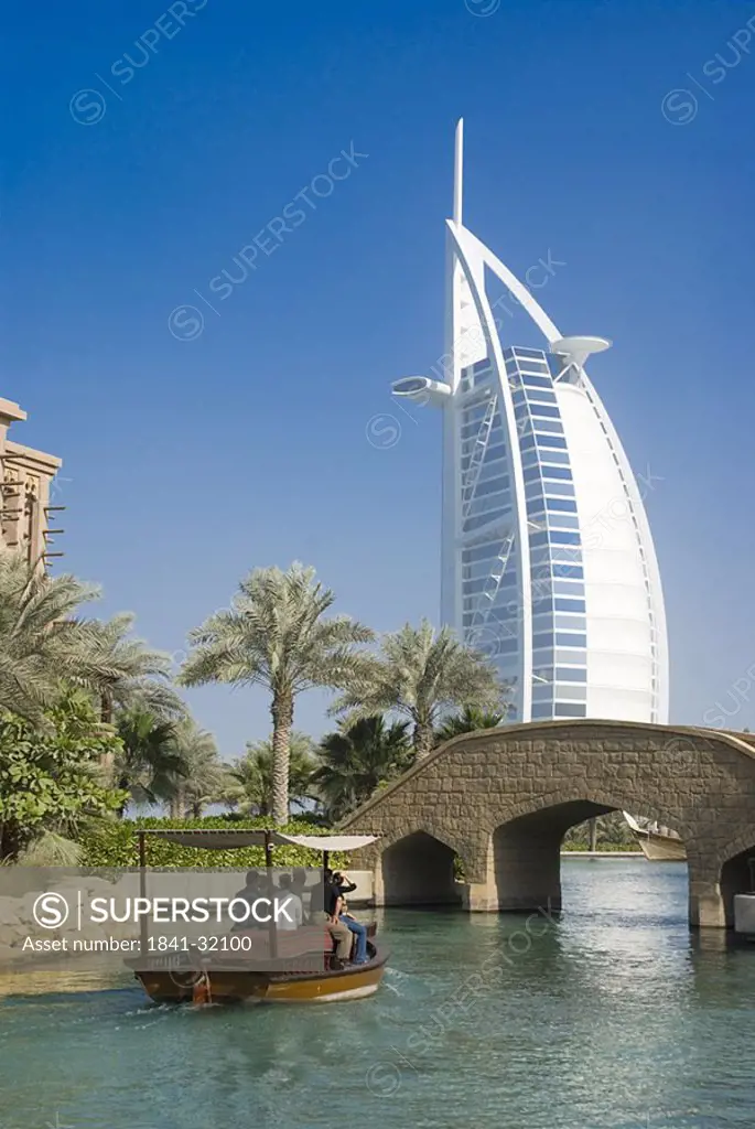 Tourists in boat with hotel in background, Burj Al Arab Hotel, Dubai, United Arab Emirates