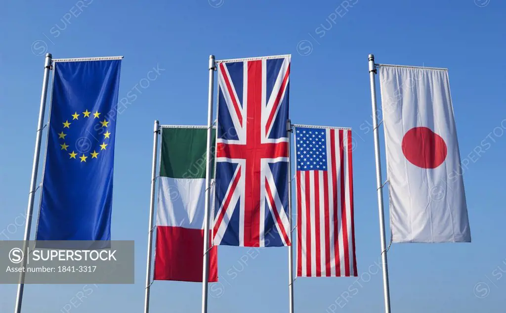 Flags of different countries against blue sky