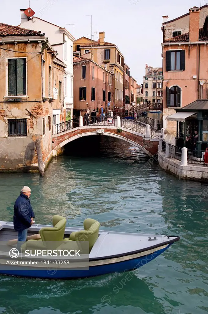 Man standing in a boot on a canal near Campo San Pantalon, Venice, Italy, elevated view