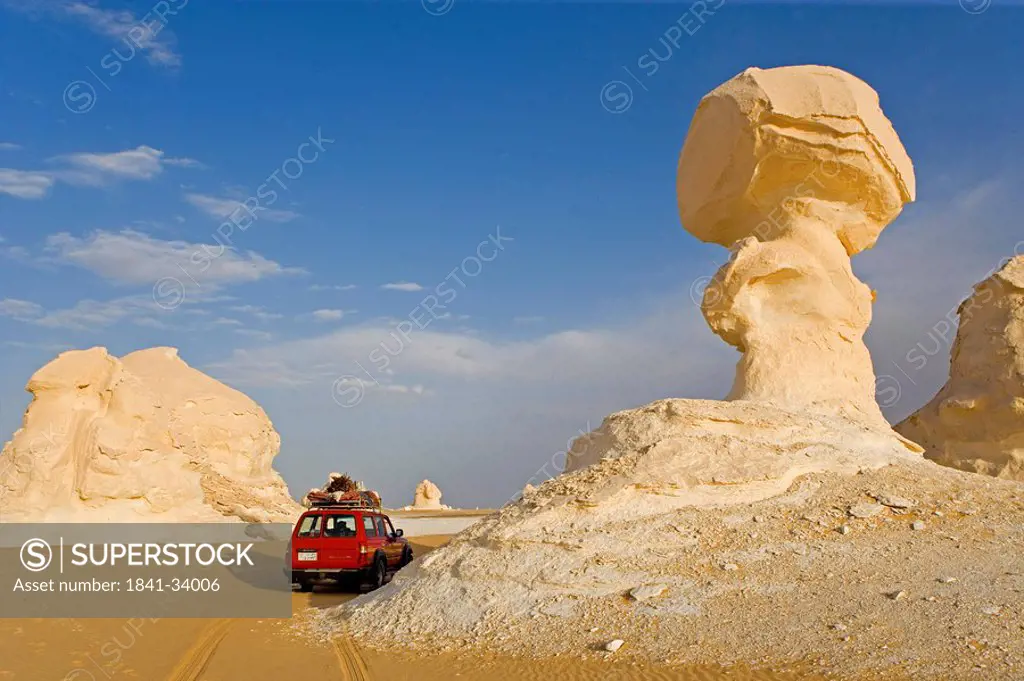 Car near rock formations in arid landscape, Farafra Oasis, Libyan Desert, Egypt