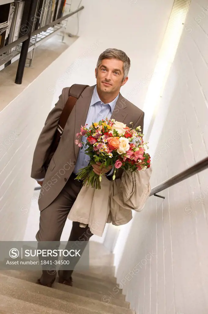 Man with a bouquet walking upstairs, elevated view