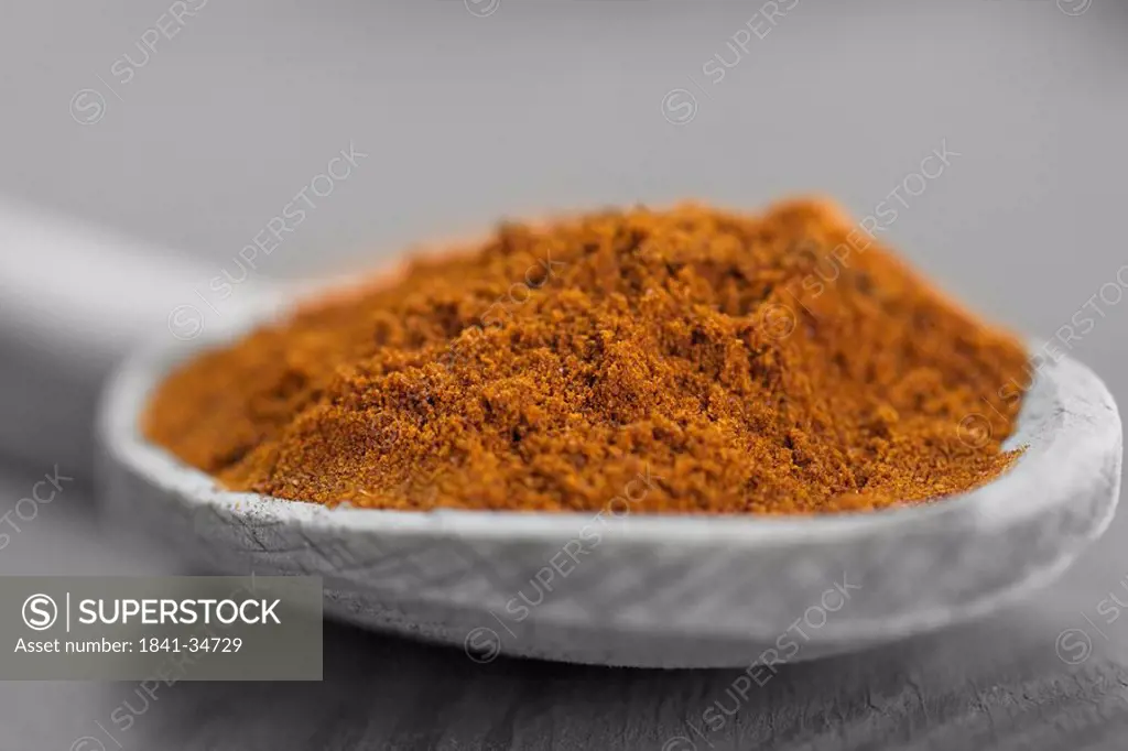 Close_up of chilli powder on wooden spoon