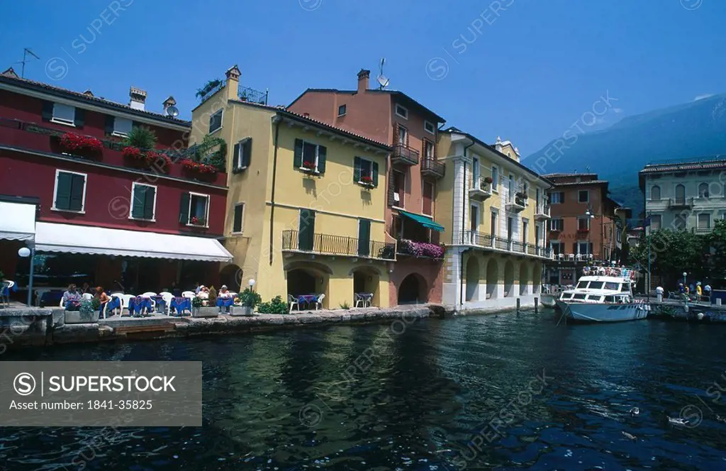 Tourists at outdoor cafe at harbor, Lago di Garda, Veneto, Italy