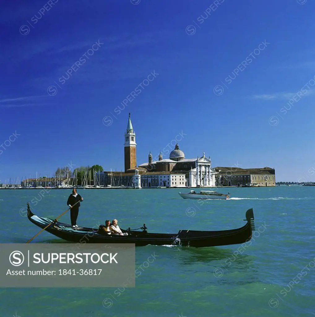 Two people sailing in gondola, Venice, Italy