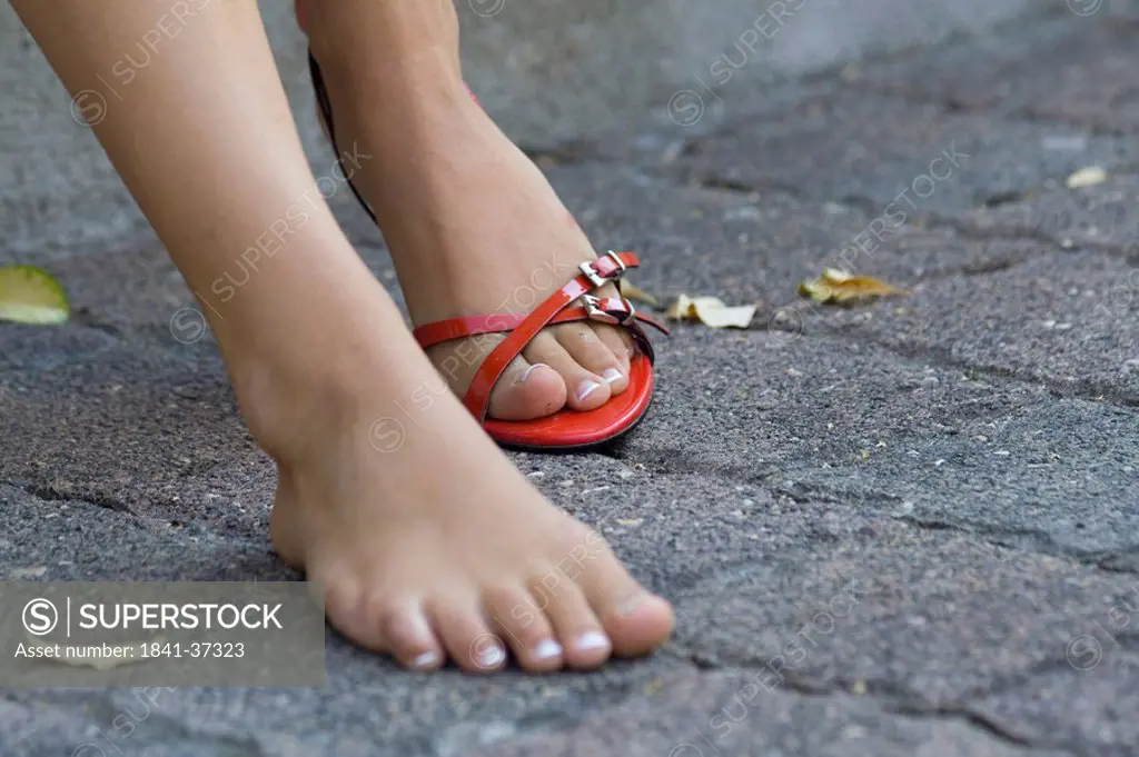 Low section view of woman taking of her sandal