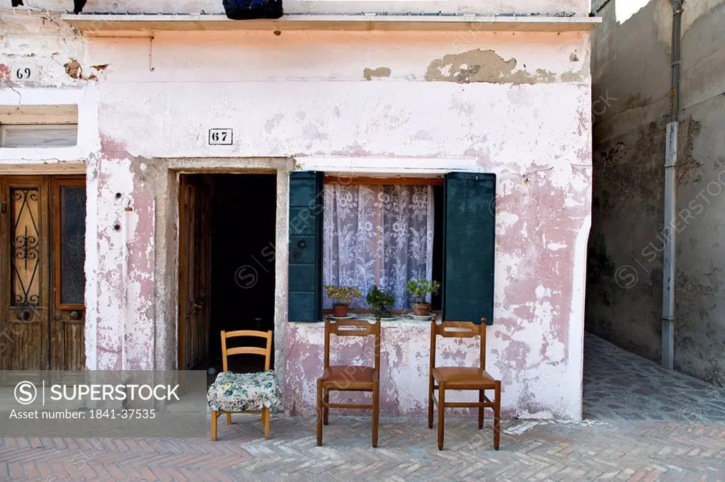 Three chairs in front of an old house, Burano, Italy