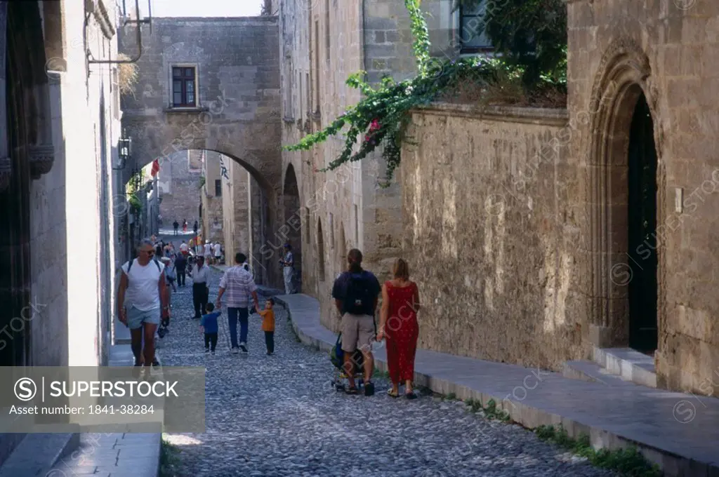 Tourists walking in lane of town, Palace of the Grand Master of the Knights, Rhodes, Dodecanese Islands, Greece