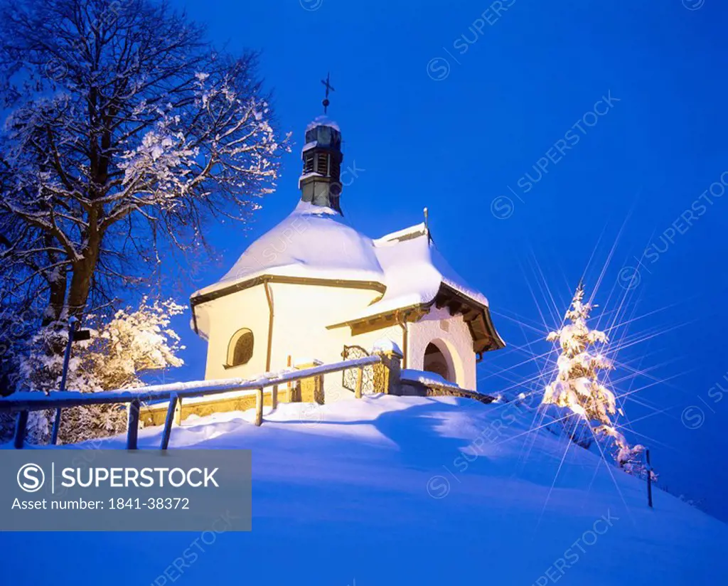Low angle view of chapel lit up at dusk, Bayersoien Chapel, Upper Bavaria, Bavaria, Germany