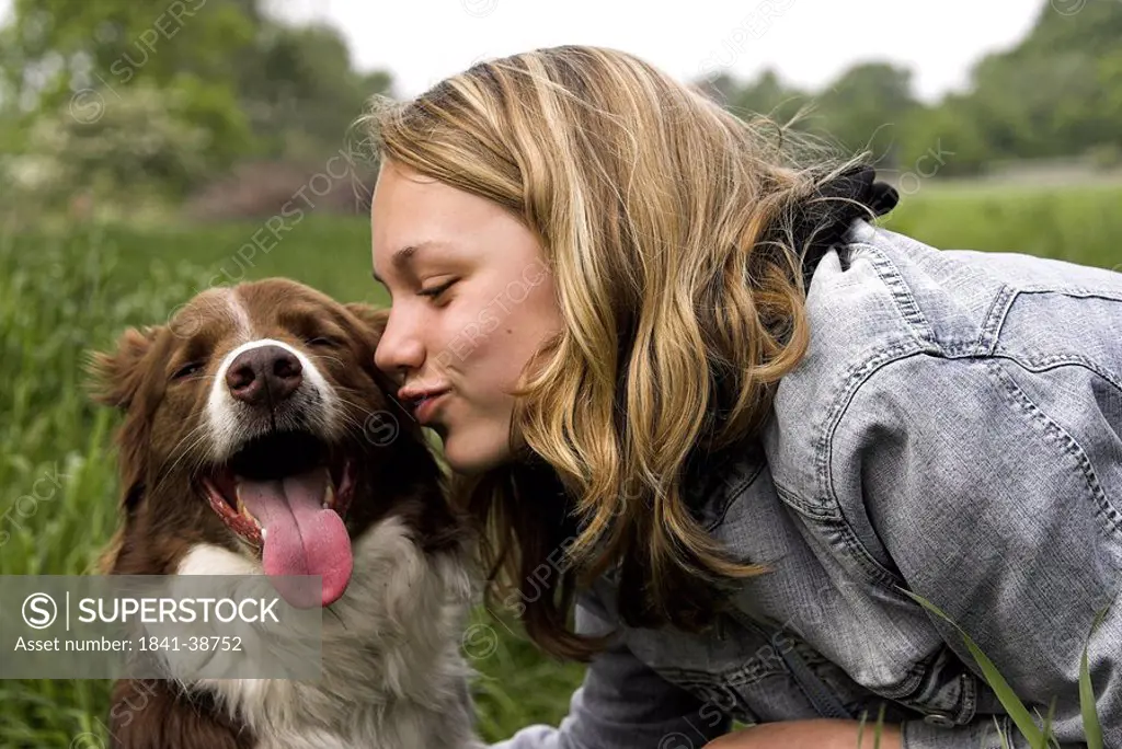 Teenage girl kissing Border Collie