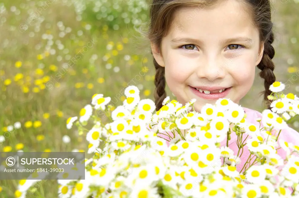 Portrait of girl holding bunch of flowers and smiling