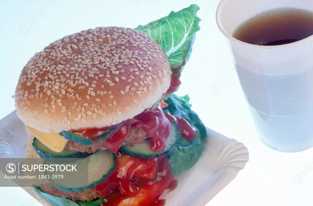 Close_up of hamburger and cup of black coffee