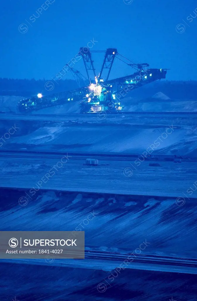 Paddlewheel excavator lit up at open pit mine, Brandenburg, Germany