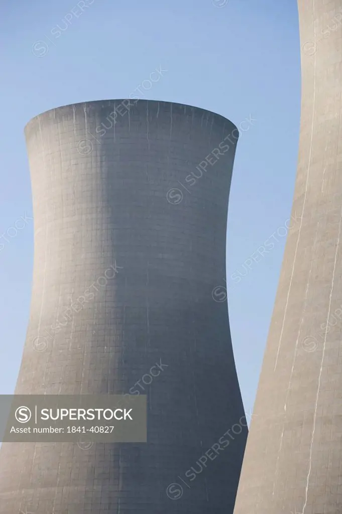 Cooling towers against clear blue sky, Kent, England