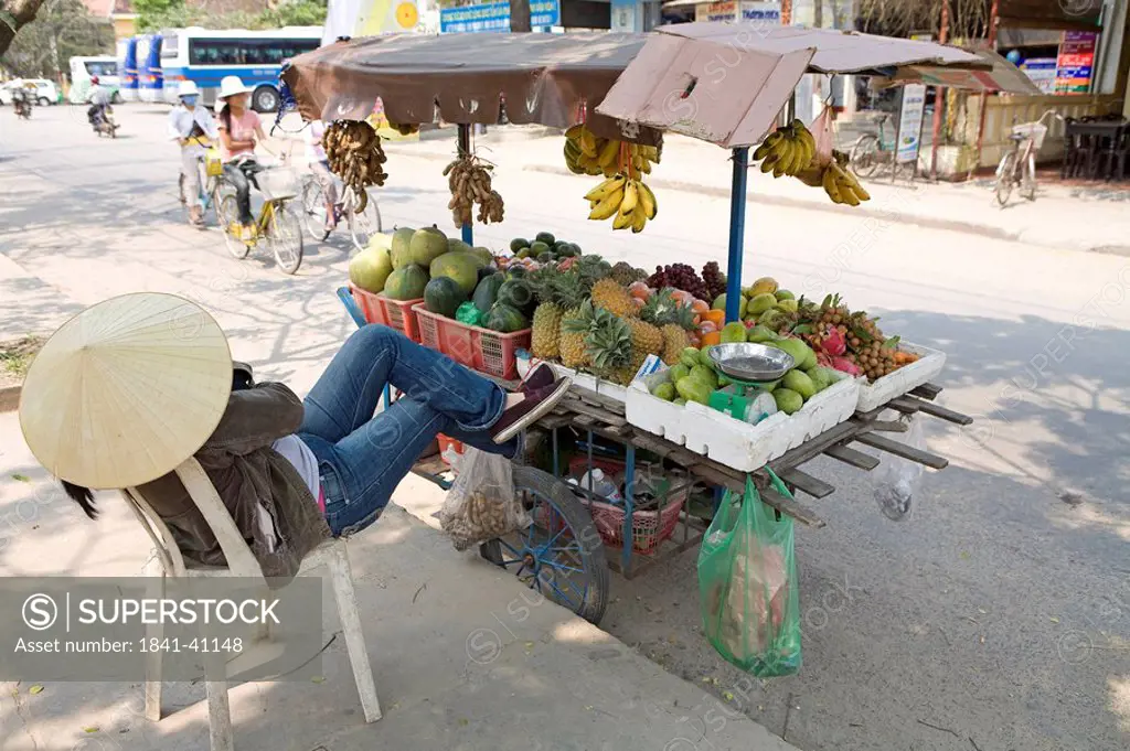 Salesperson at a fruit stand on a street, Hoi An, Vietnam