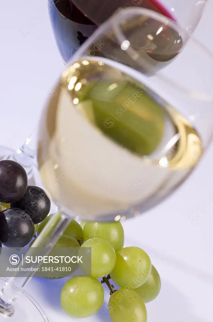 Low angle view of glass of white wine and grapes