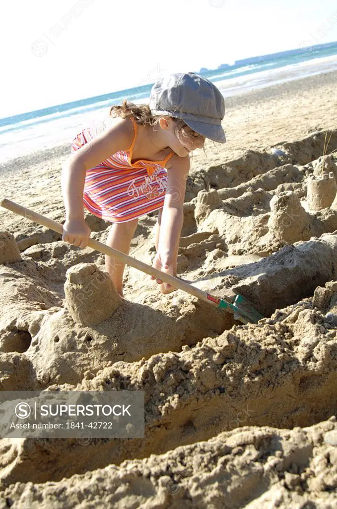 Girl making sandcastle on beach and smiling