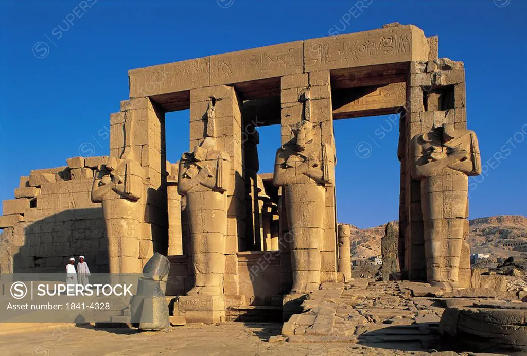 Two people standing near ruins of temple, Great Temple of Rameses II, Luxor, Egypt