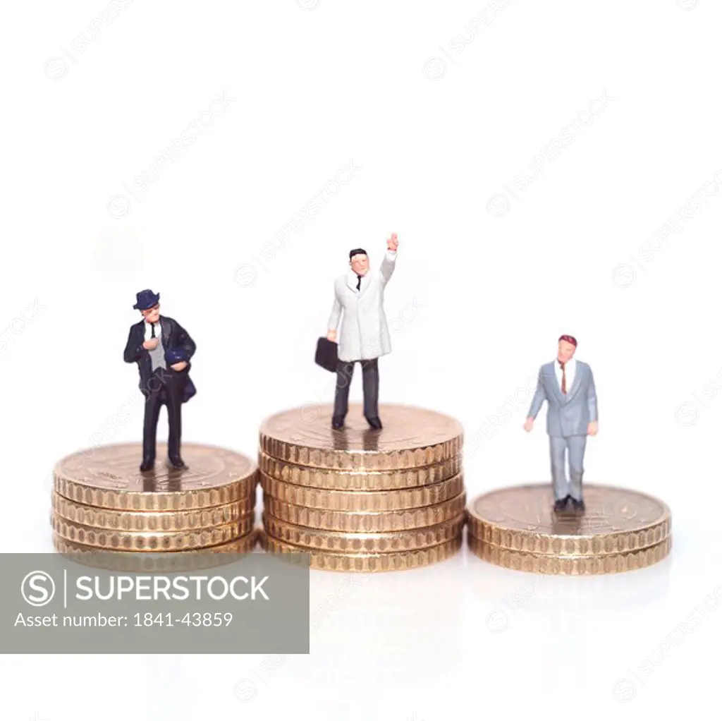 Figurines of businessmen with stacks of coins