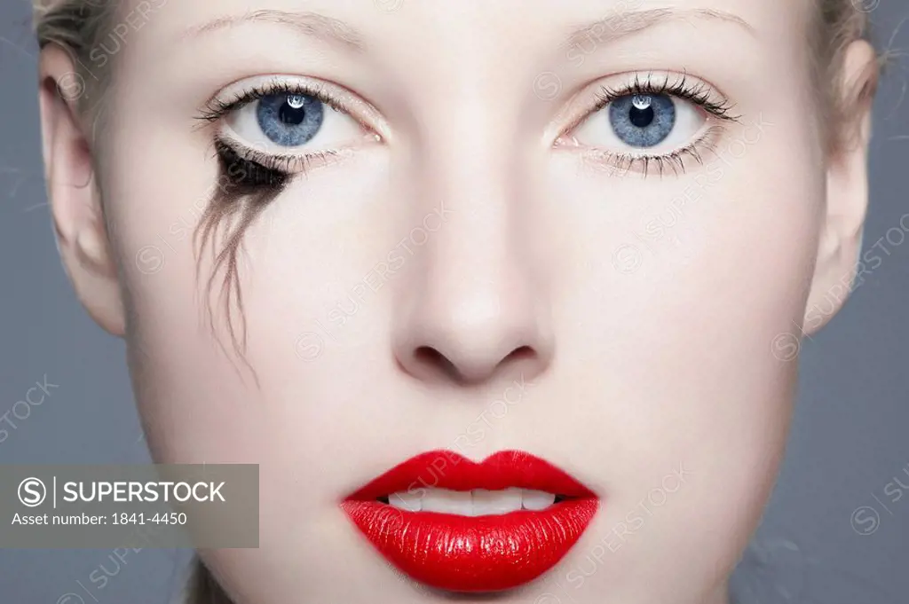 Young woman with red lips and blurred eyeliner, portrait