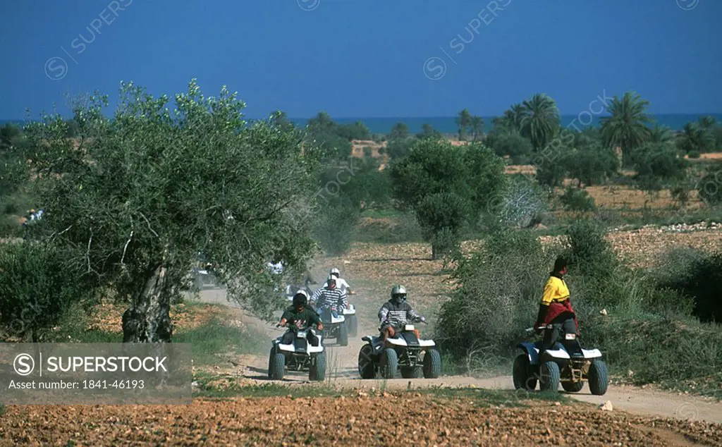 Quad bikers racing on dirt road, Djerba, Tunisia