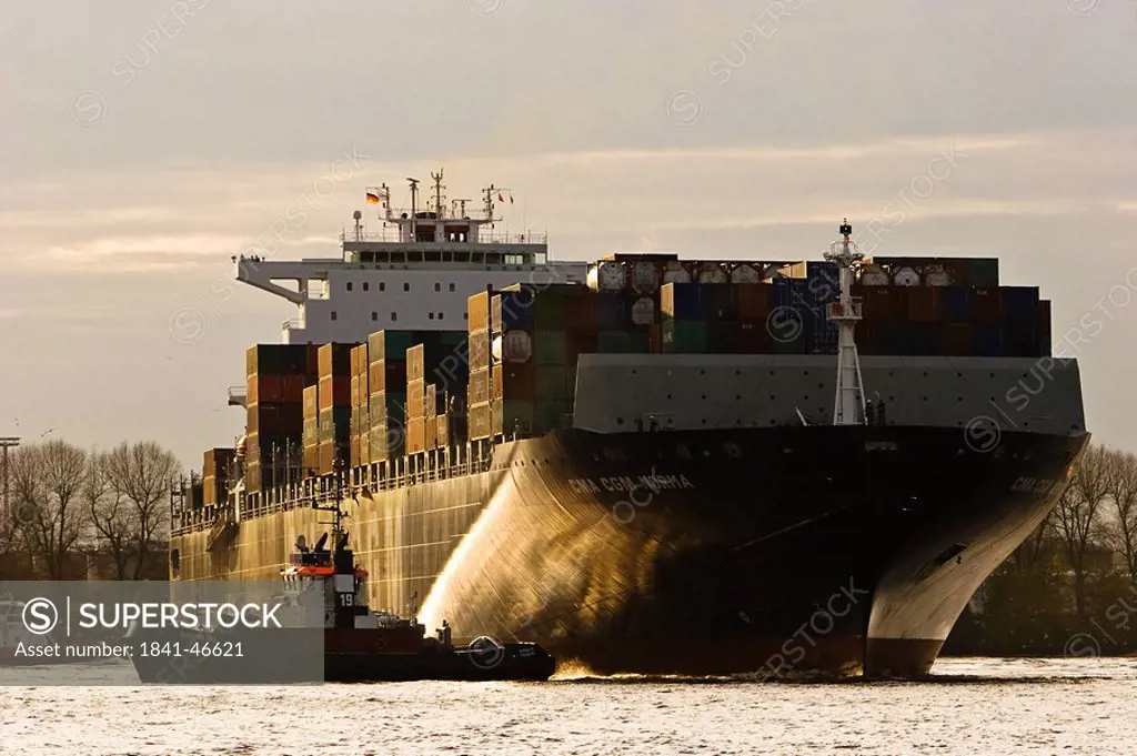 Tugboat pulling cargo ship, Hamburg harbour, Germany