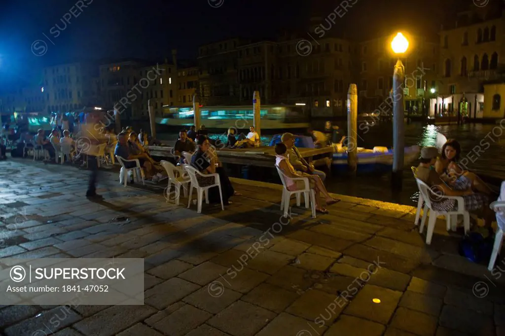 Tourists near canal at night, Campo Della Pescaria, Veneto, Venice, Italy