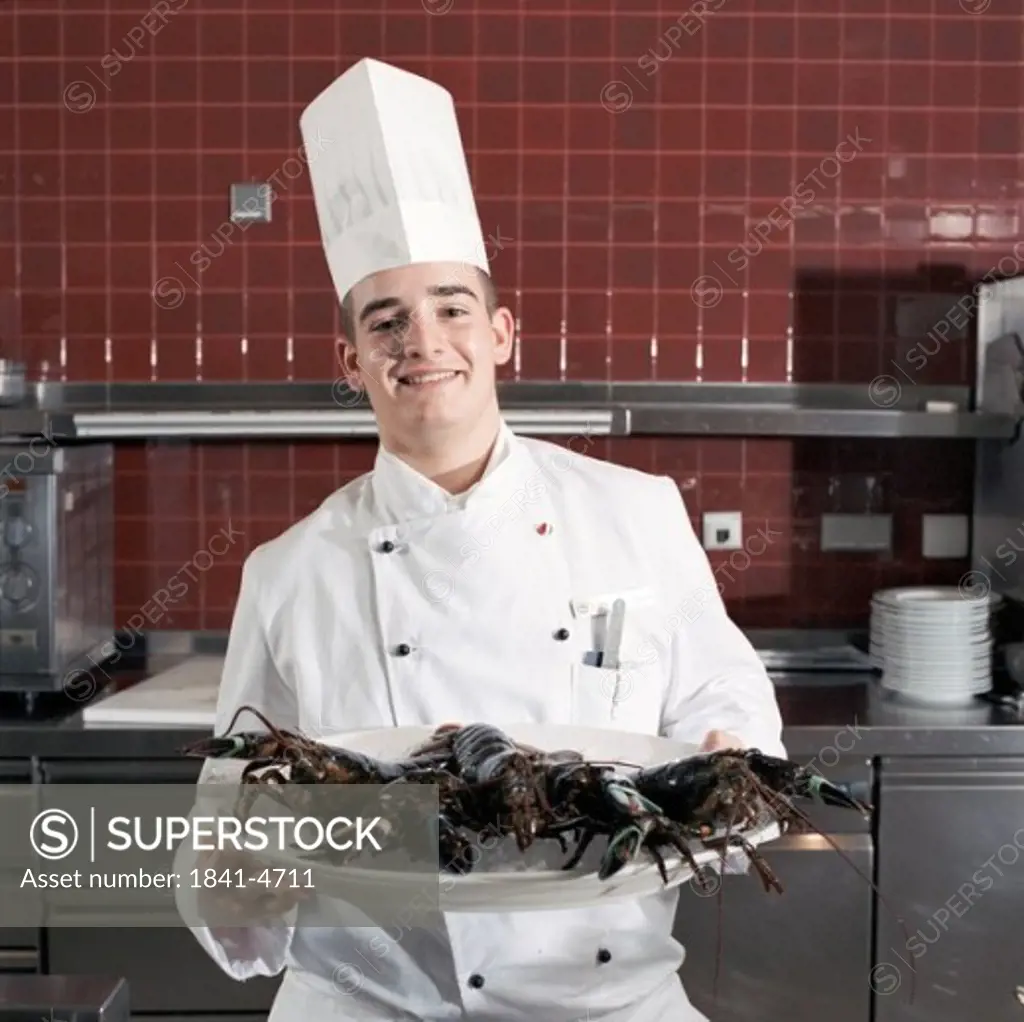 Cook holding plate with lobsters