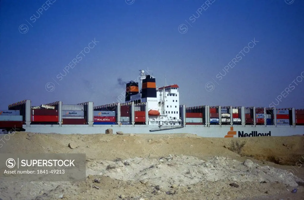 Cargo ship in canal against blue sky, Suez Ship Canal, Egypt