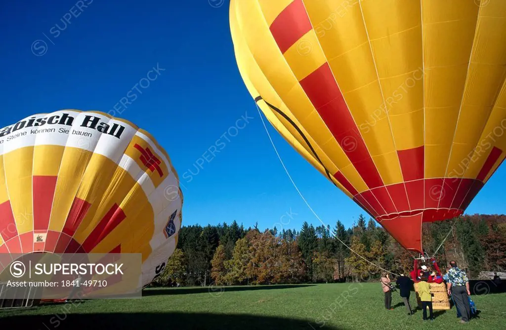 People around hot air balloon on landscape, Sonnenbuehl, Swabian Alps, Baden_Wuerttemberg, Germany