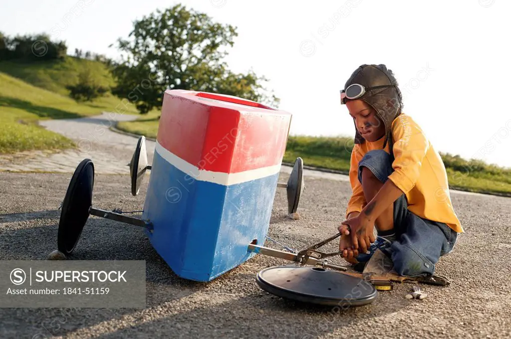 Boy repairing a soap box