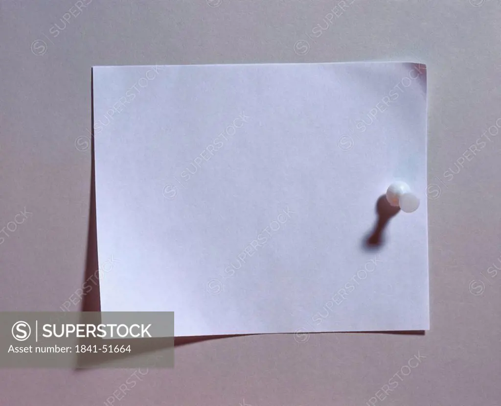 Close_up of paper and thumbtack