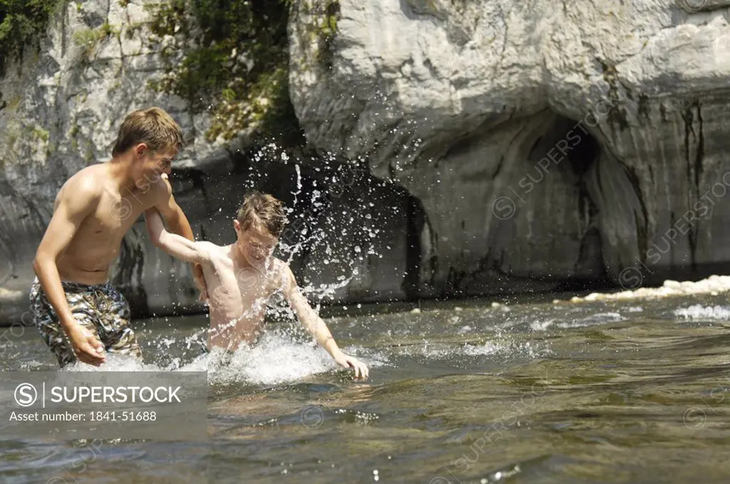 Two brothers playing in river