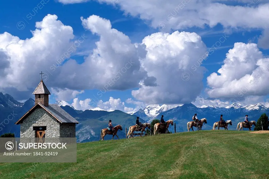Tourists riding on horses with mountain range in background, Hohe Tauern, Alps, Moelltal, Carinthia, Austria