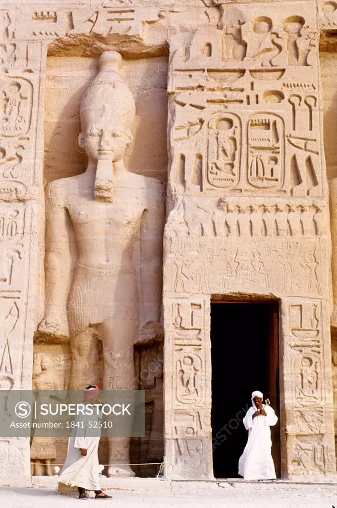 Two people in front of Egyptian temple, Nefertaris Temple Of Hathor, Abu Simbel, Egypt
