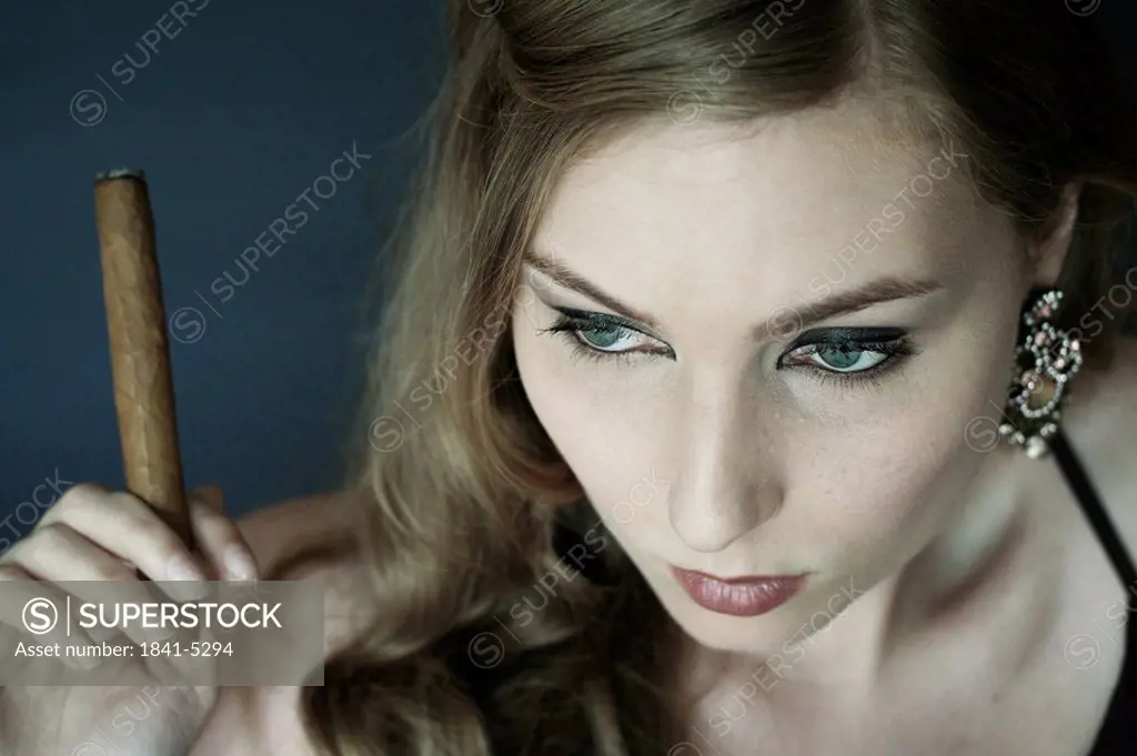 Close_up of young woman smoking cigar