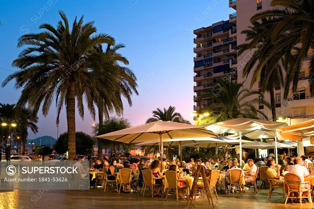 Tourists at sidewalk cafe at dusk, Ibiza, Balearic Islands, Spain
