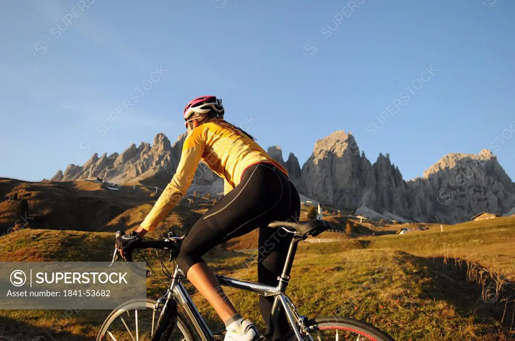 Close_up of mountain biker in front of mountains, Dolomites, Italy
