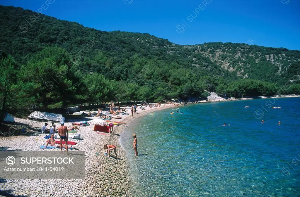 Tourists on beach, Cres Island, Croatia