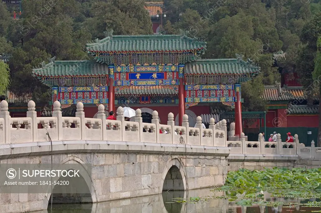 Tourists on bridge across pond, Beihai Park, Beijing, China